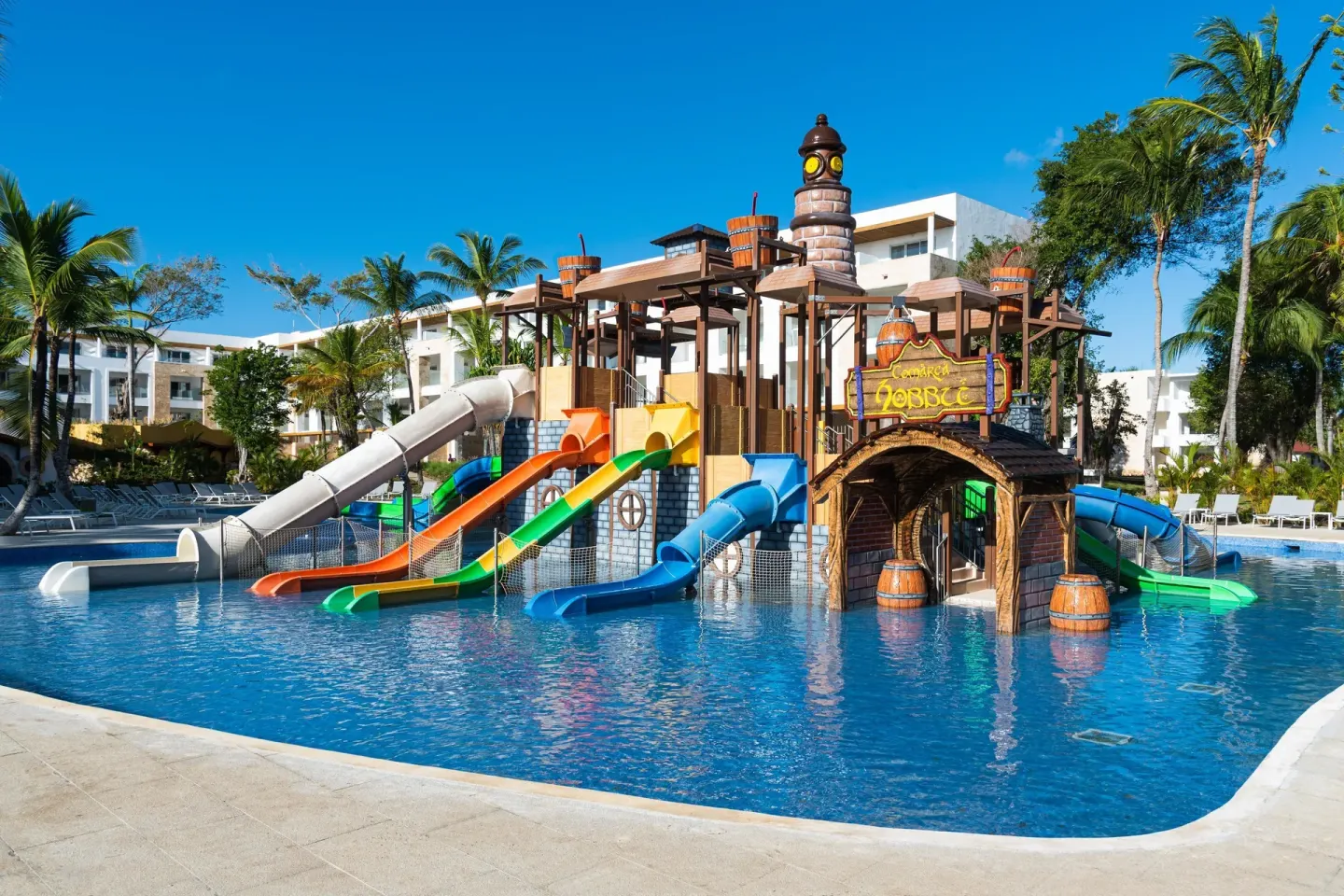 Kids' pool with multiple colorful slides and pirate play structure at Princess Family Club Bavaro.
