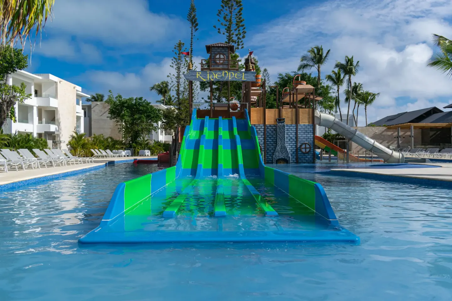 Wide green and blue kids' slide into the pool at Princess Family Club Bavaro.