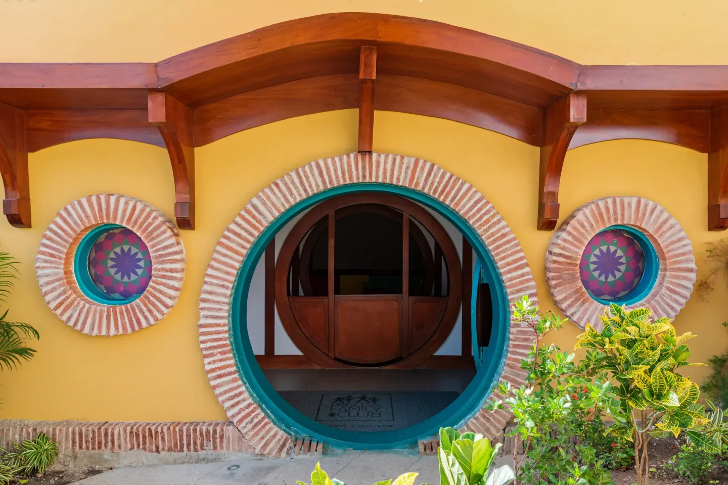 Yellow round-door building entrance with brick trim at Princess Family Club Bavaro.