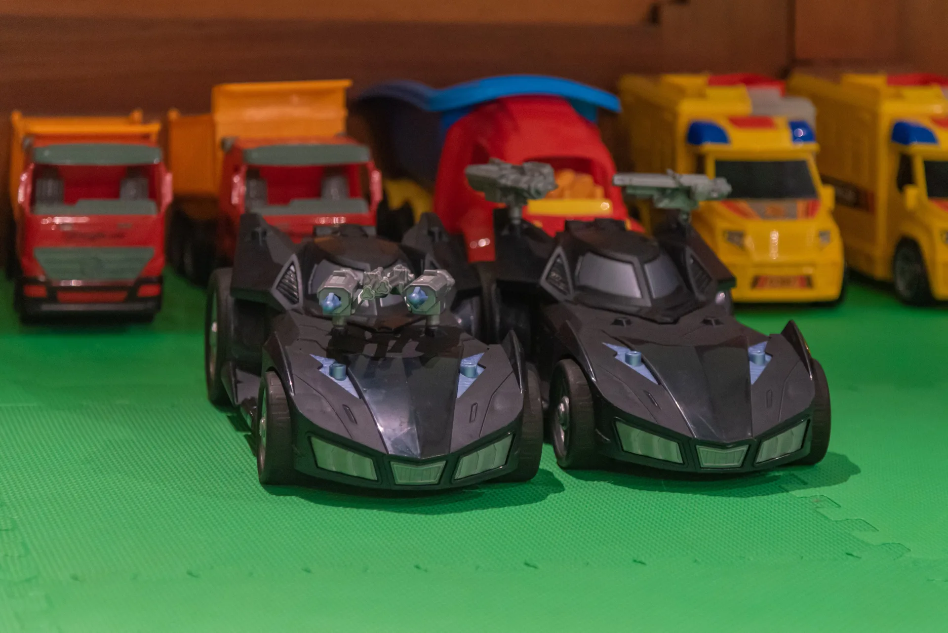 Toy cars lined up on green play flooring at Princess Family Club Bavaro.