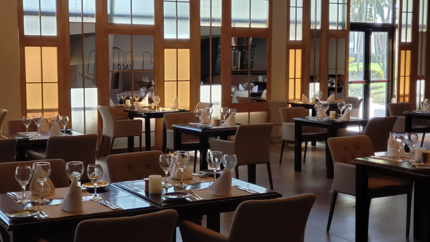 Elegant restaurant tables set for dinner at Princess Family Club Bavaro.