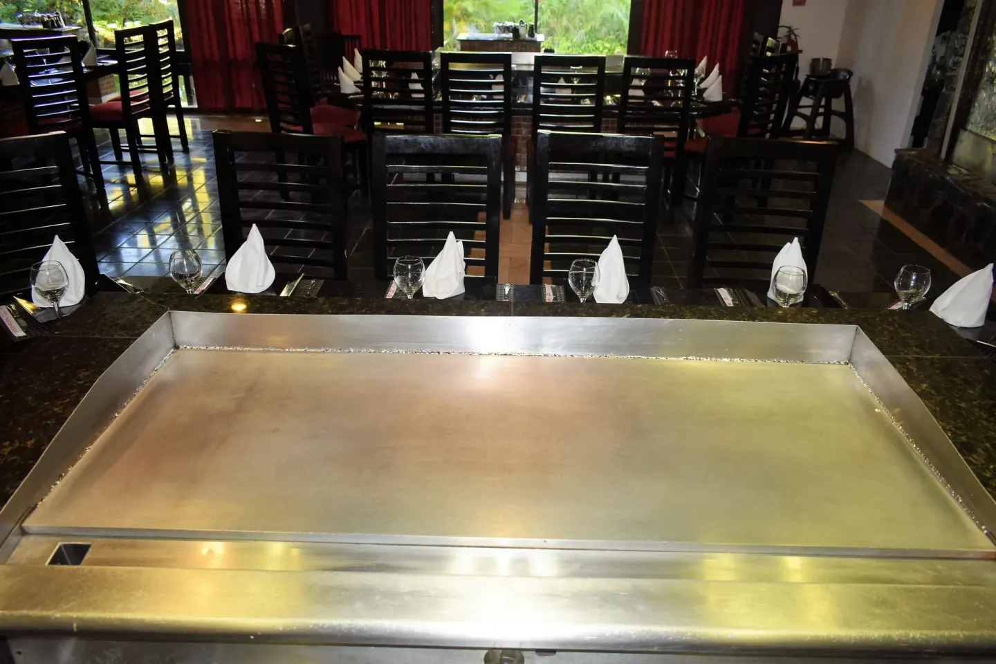 Teppanyaki grill table with chairs and place settings at Princess Family Club Bavaro.
