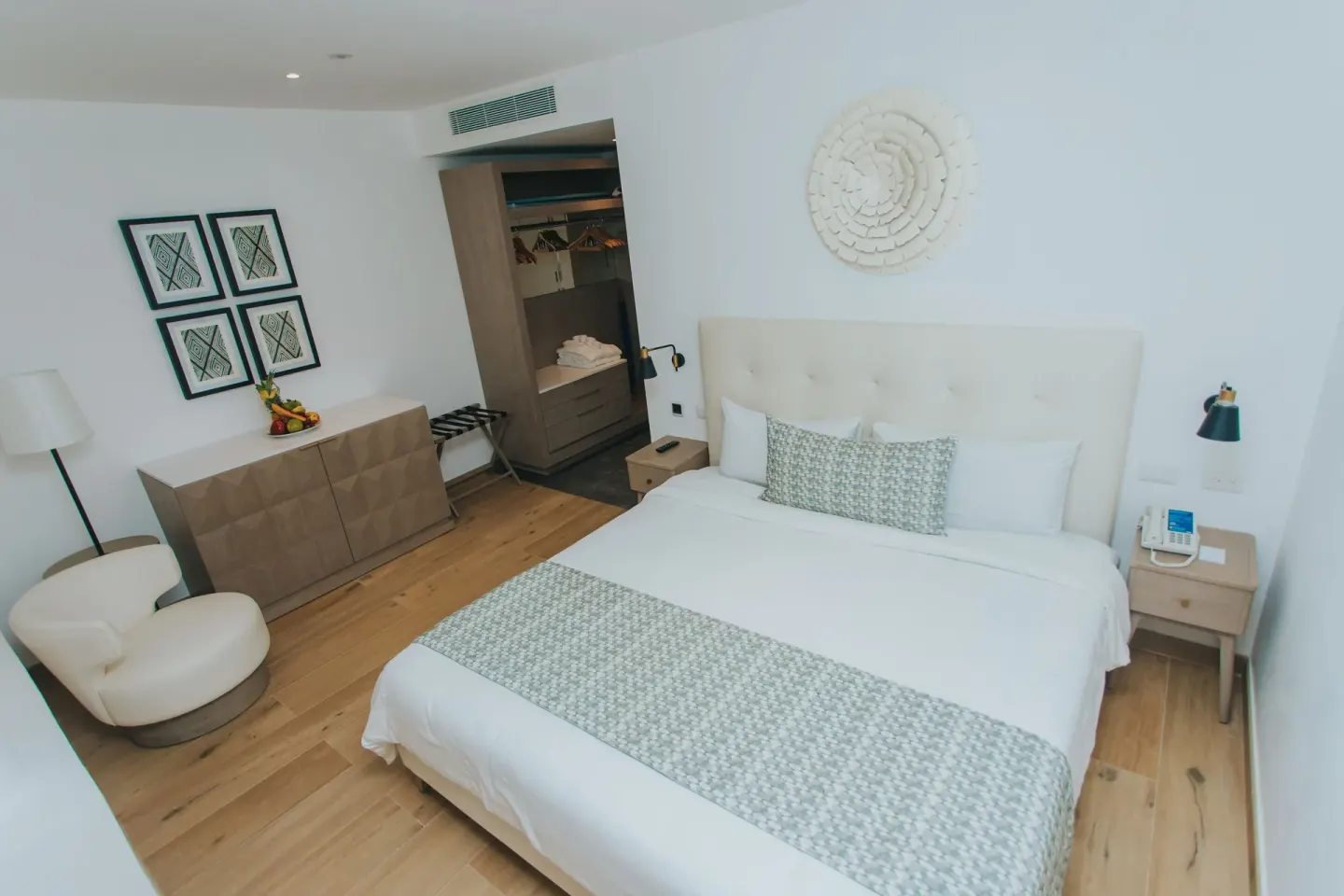 Family Club Junior Suite Swimout king bed, dresser, and closet at Princess Family Club Bavaro.