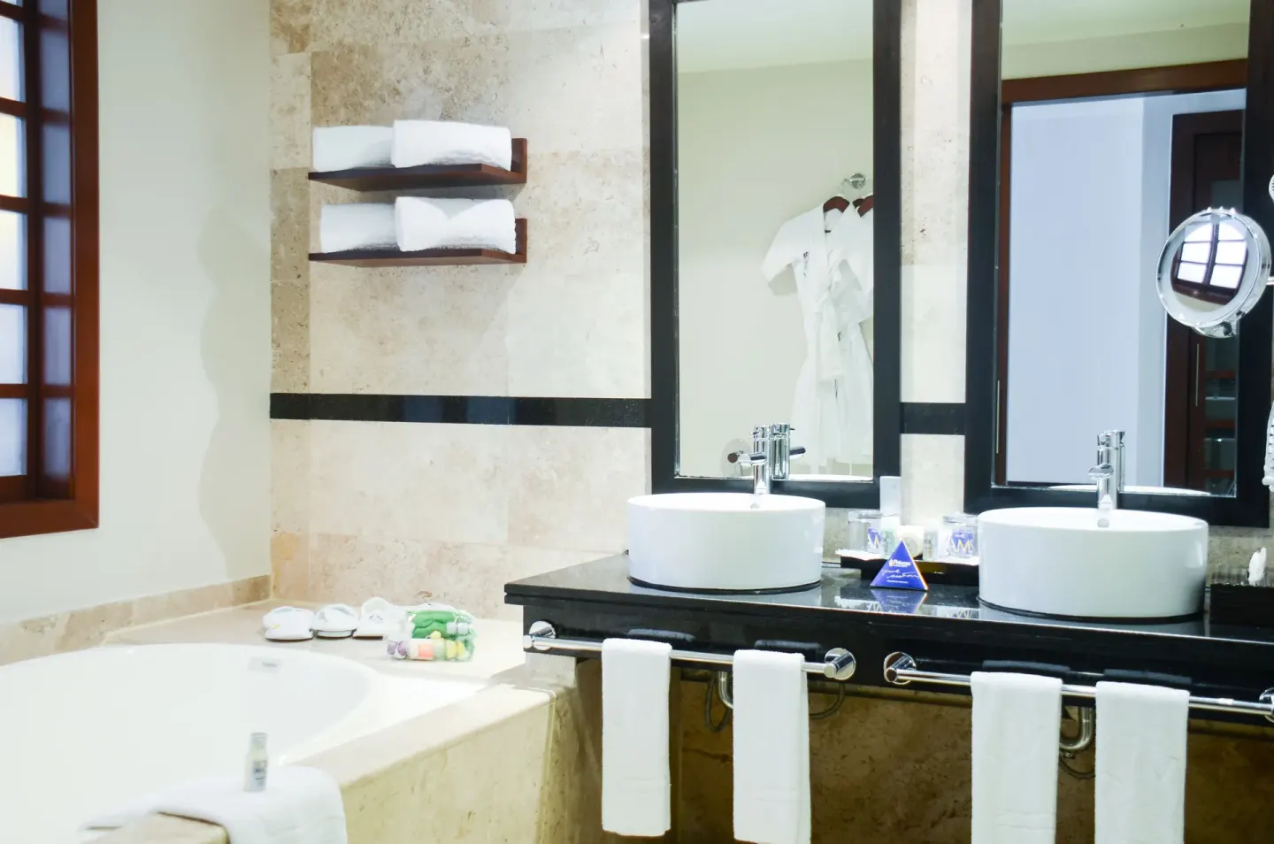 Bathroom with double sinks, soaking tub, and robes at Princess Family Club Riviera.