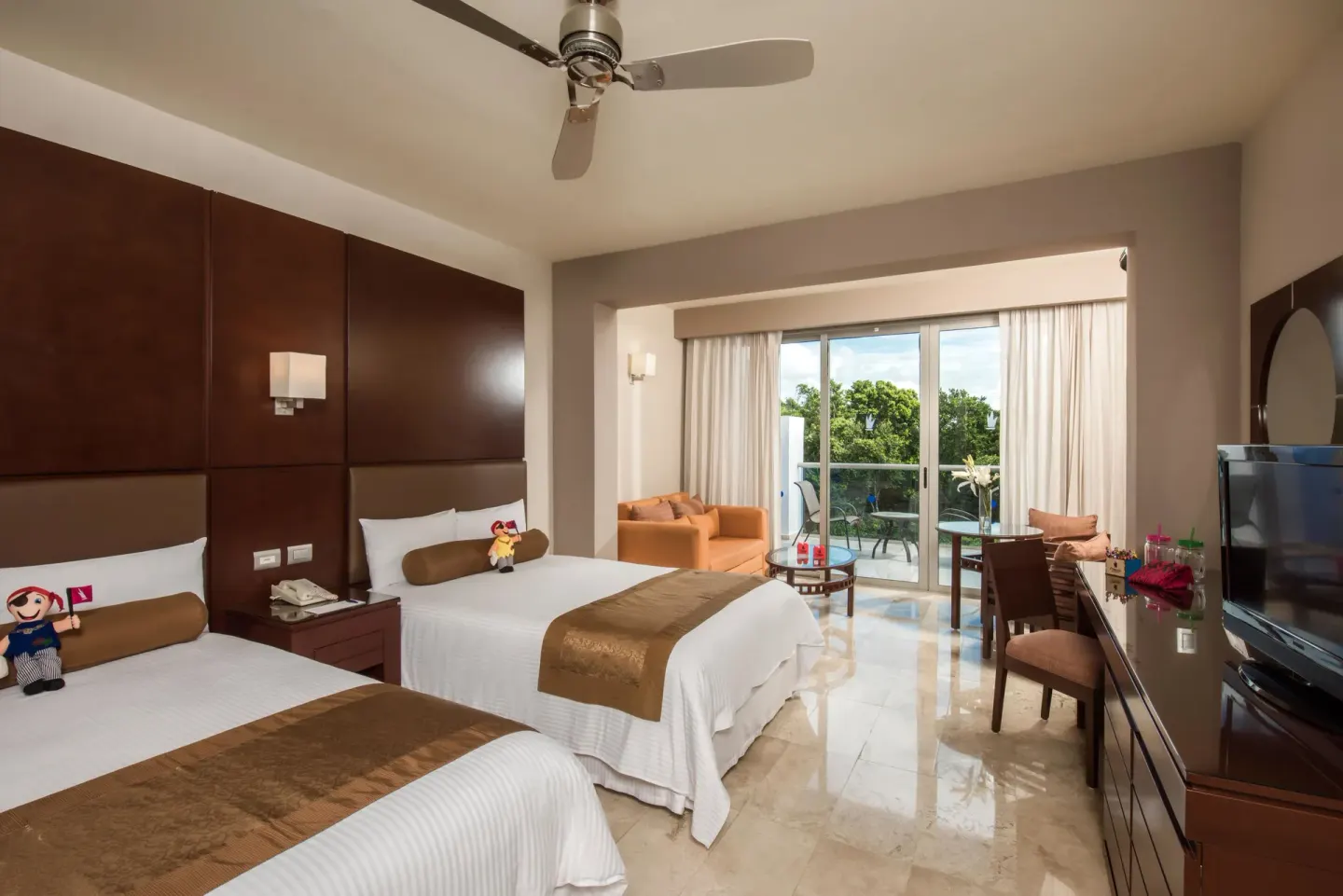 Guest room with two double beds and balcony seating at Princess Family Club Riviera.