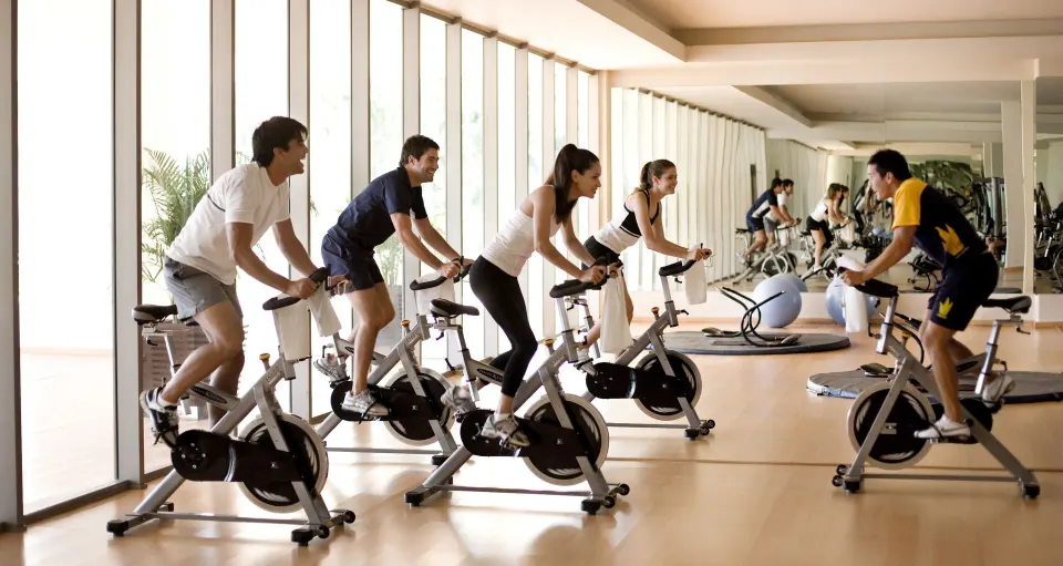 Guests take a group indoor cycling class in the fitness room at Princess Family Club Riviera.