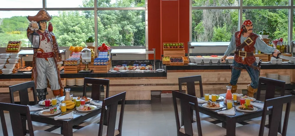 Breakfast buffet at Princess Family Club Riviera with pirate figures, set tables, juices, and fruit displays.