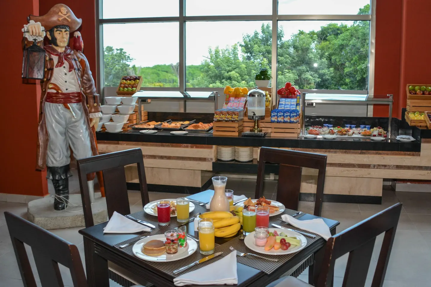 Breakfast table at Princess Family Club Riviera set with juices, fruit, pancakes, and a pirate figure nearby.