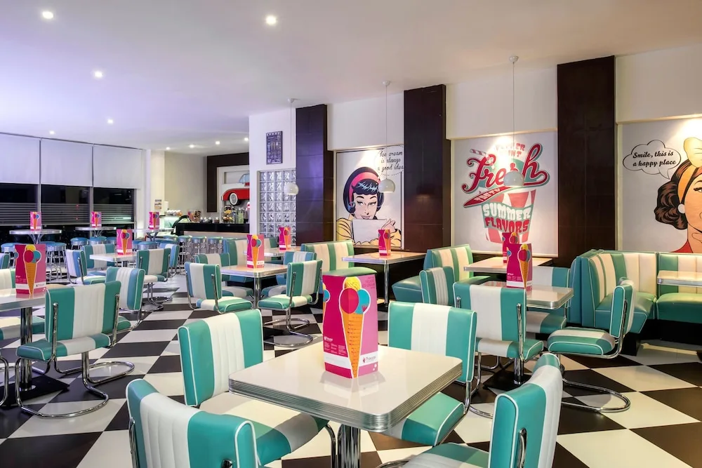 Retro diner-style seating at Princess Family Club Riviera with turquoise chairs and checkered flooring.