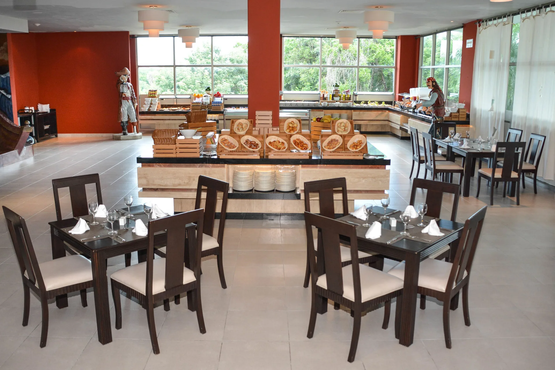Spacious buffet restaurant at Princess Family Club Riviera with set tables, bread displays, and large windows.