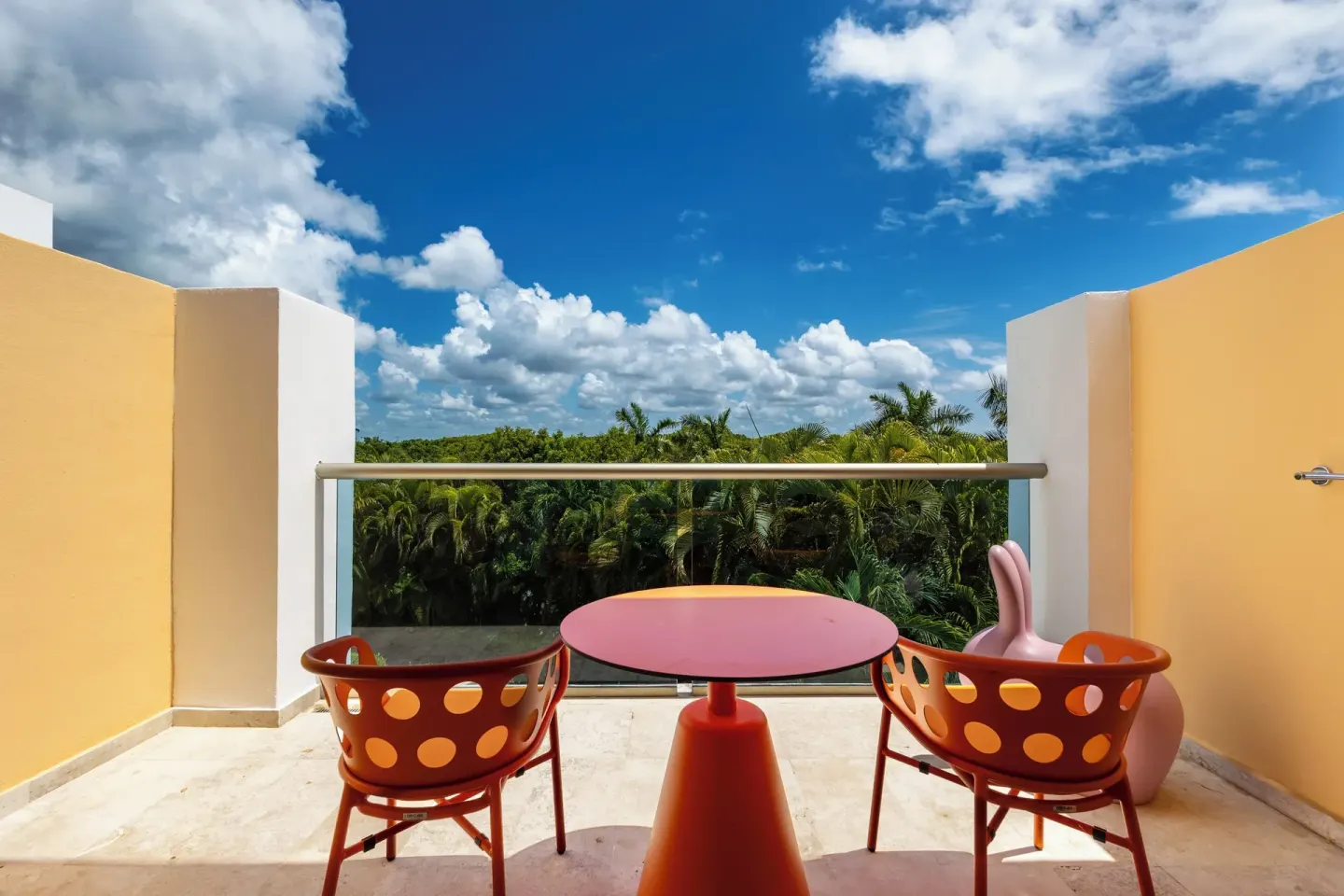 Family Room balcony with orange chairs and treetop view at Princess Family Club Riviera.