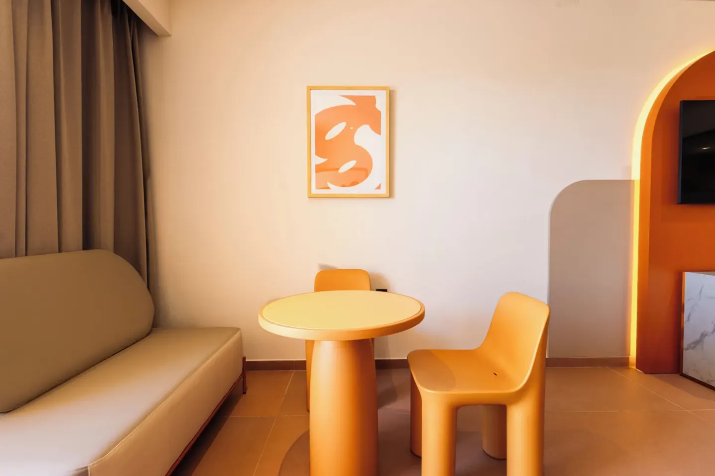 Family Room seating area with sofa, round table and orange chairs at Princess Family Club Riviera.