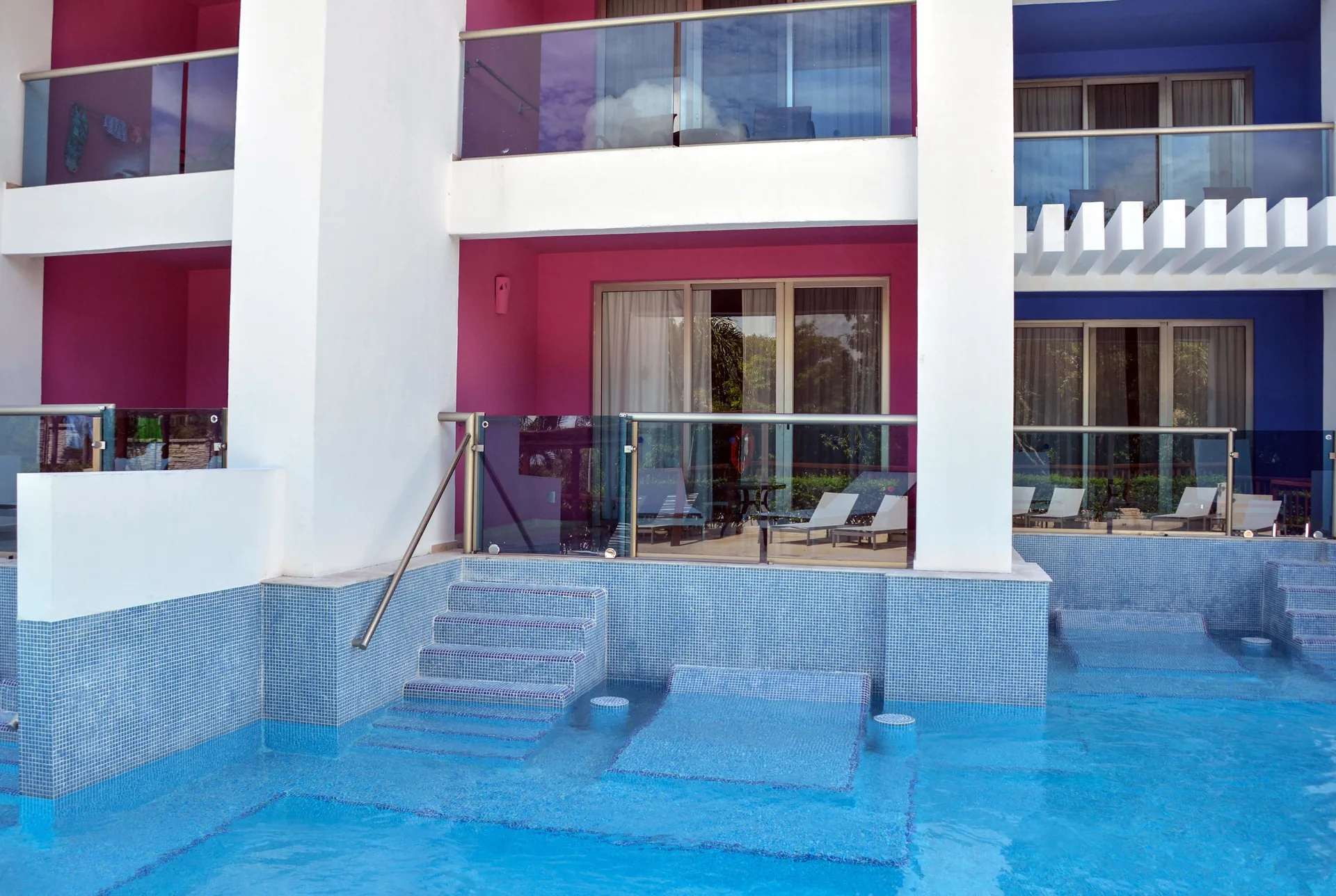Pool access rooms at Princess Family Club Riviera with submerged steps and colorful balcony walls.