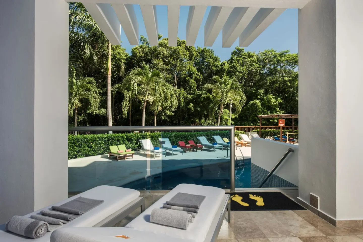 Pool access patio at Princess Family Club Riviera with two loungers, towels and steps into the pool.