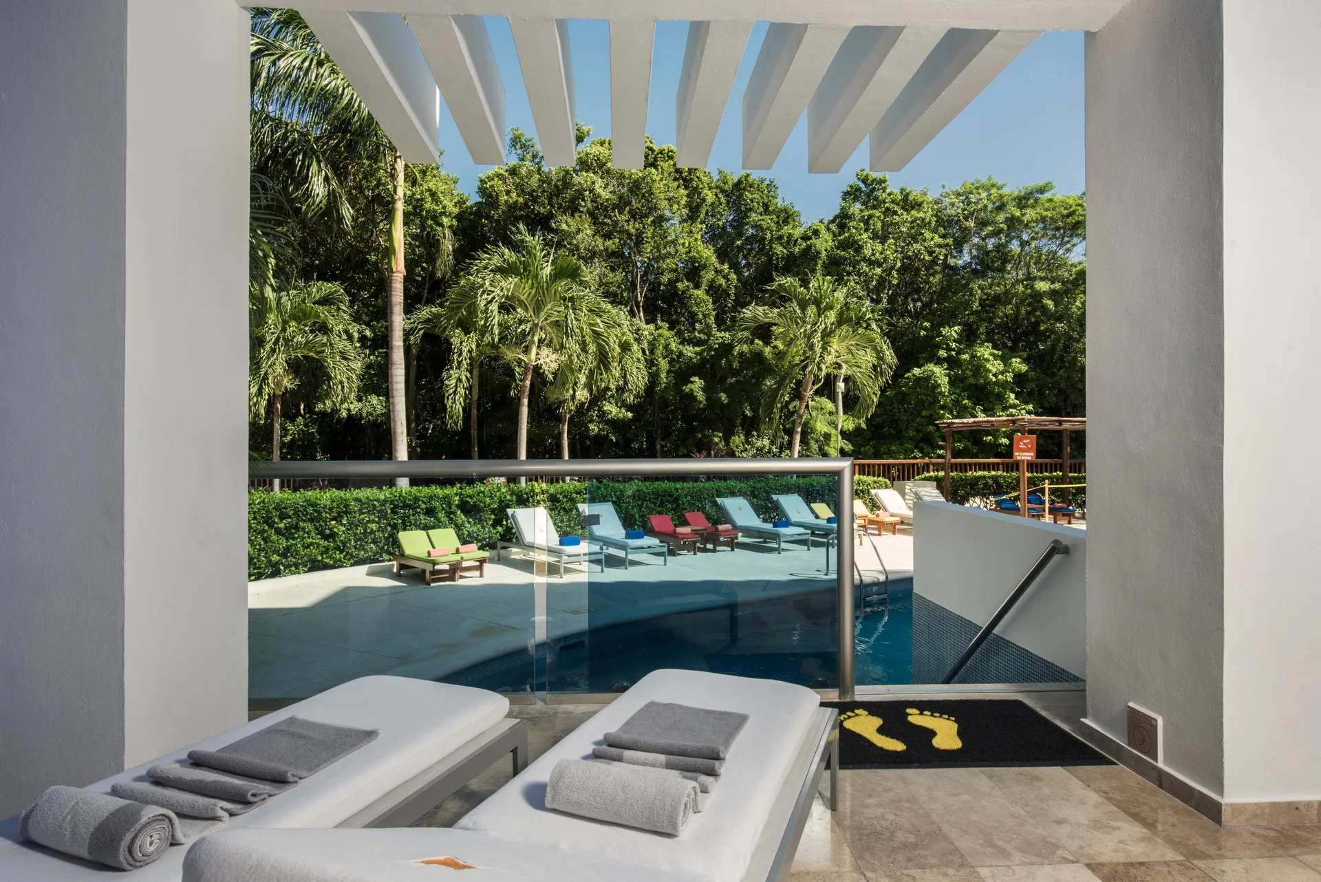Pool access patio at Princess Family Club Riviera with two loungers, towels and steps into the pool.