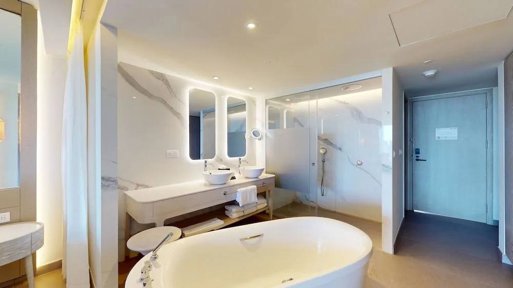 Open bathroom with soaking tub, double vanity and glass shower at Princess Grand Jamaica Resort.