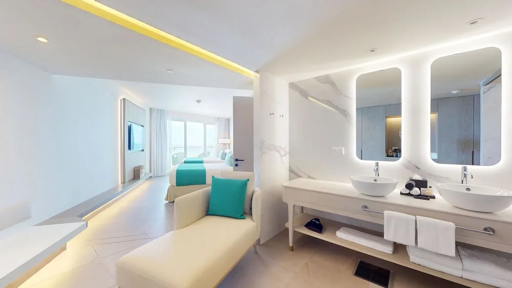 Guest room bathroom vanity beside a bedroom at Princess Grand Jamaica Resort.
