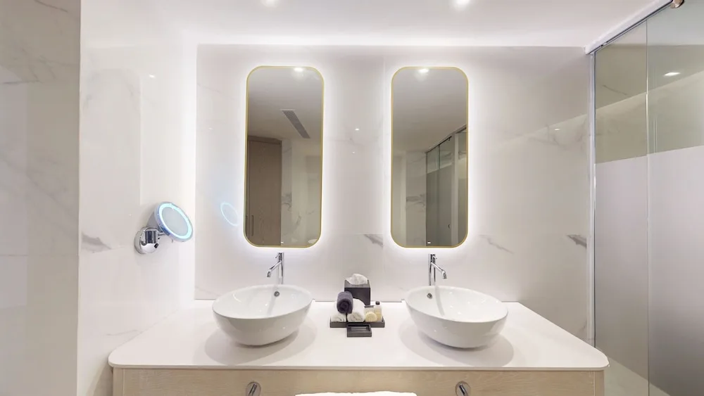 Double-sink bathroom vanity with lit mirrors at Princess Grand Jamaica Resort.