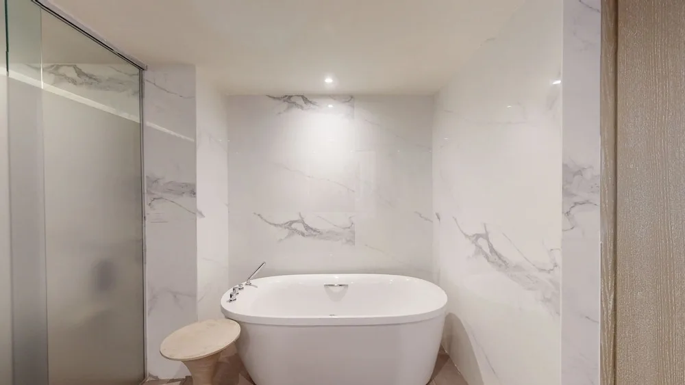 Freestanding bathtub beside a glass shower at Princess Grand Jamaica Resort.