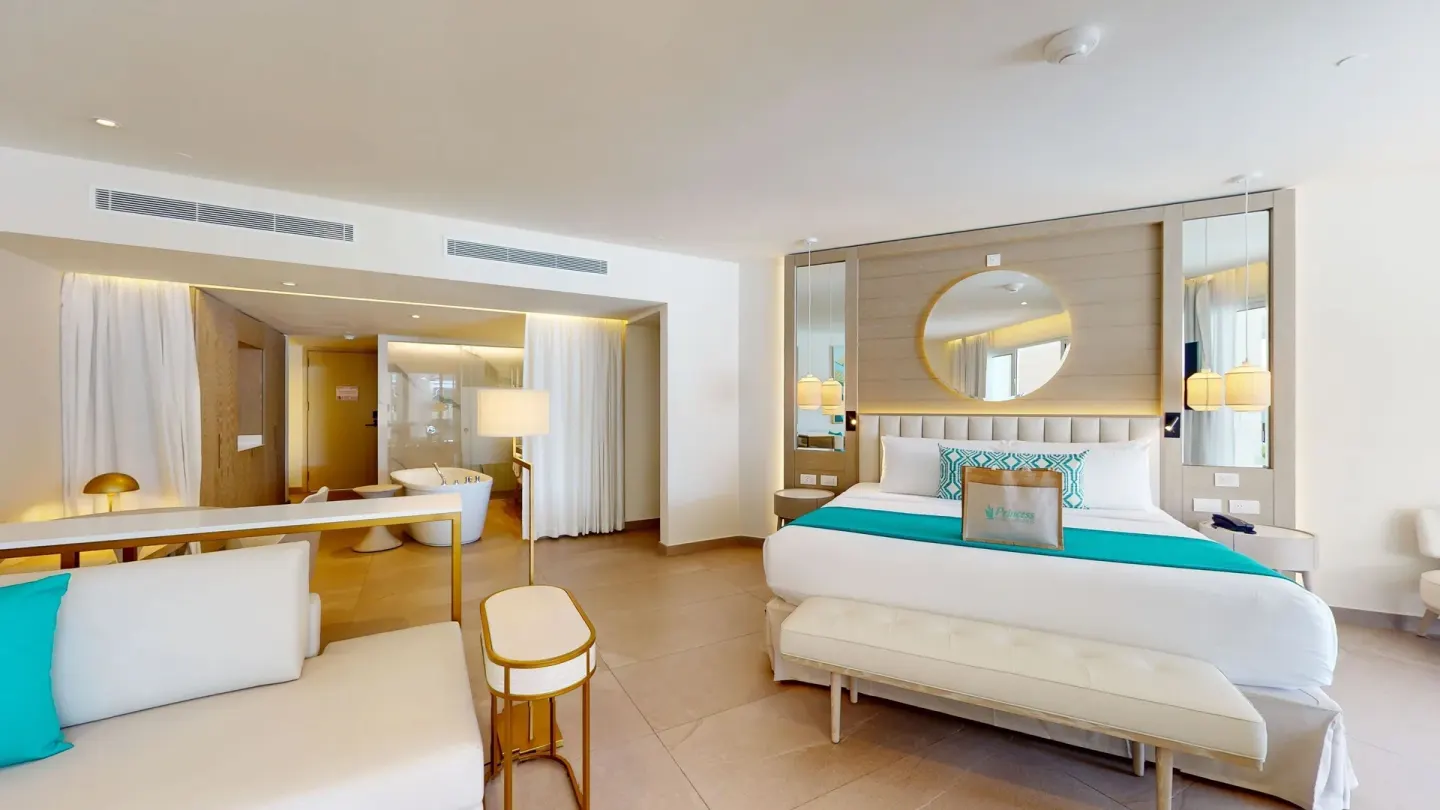Bright guest room with king bed and soaking tub at Princess Grand Jamaica Resort.