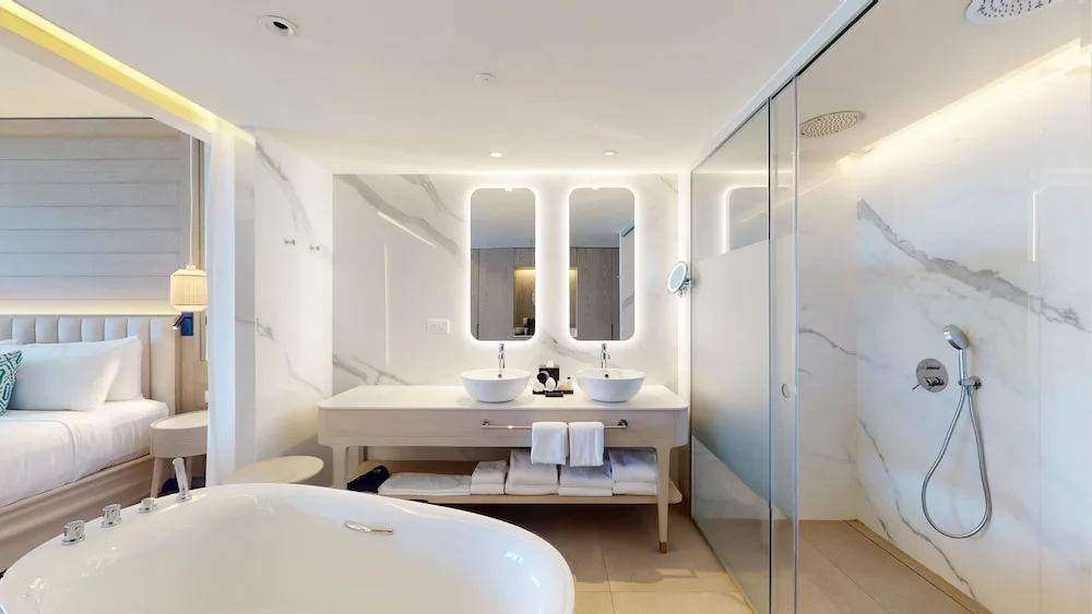 Open bathroom with tub, double vanity and shower at Princess Grand Jamaica Resort.