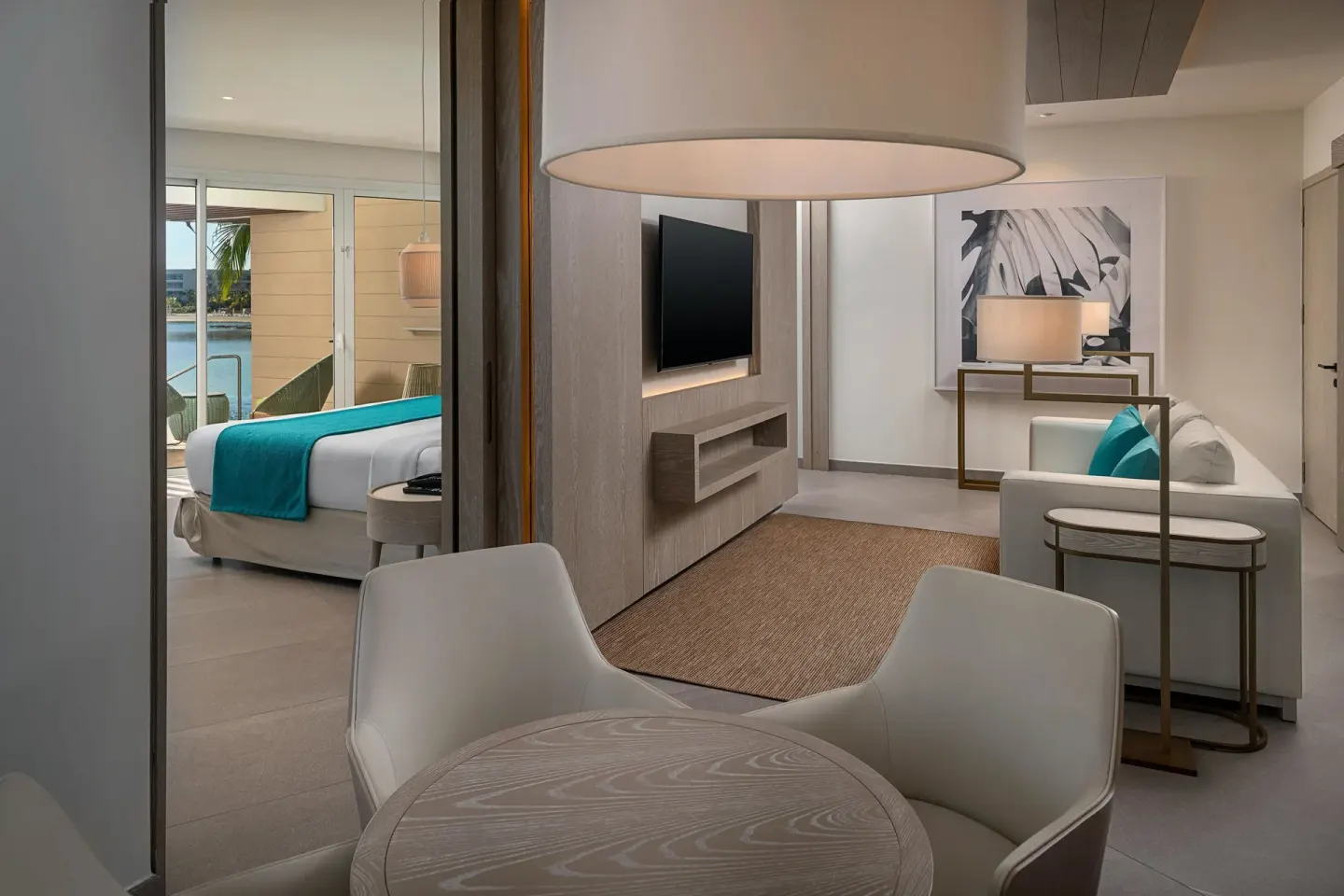 Suite living area with dining table, sofa and bedroom beyond at Princess Grand Jamaica Resort.