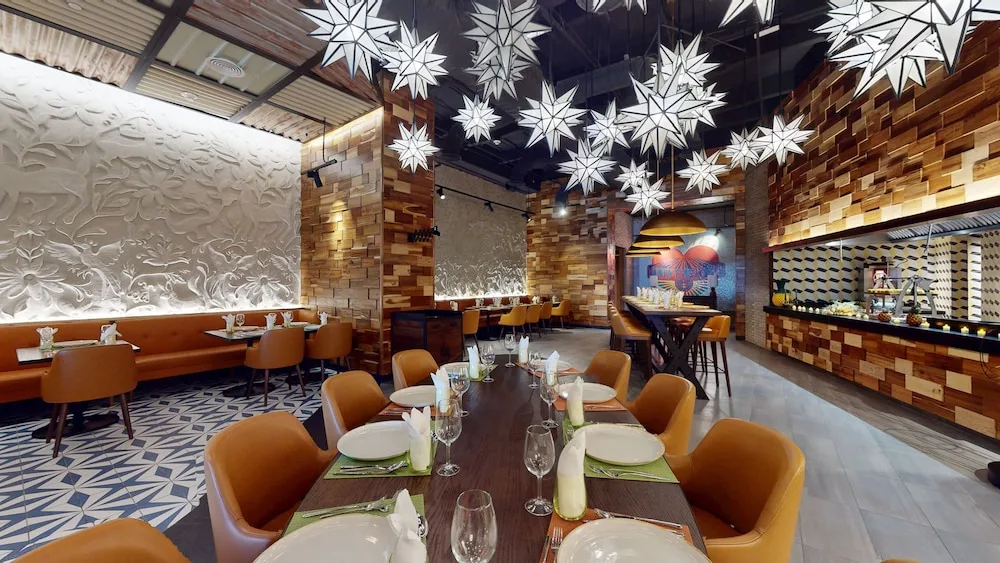 Restaurant dining room with star pendant lights and set tables at Princess Grand Jamaica Resort.