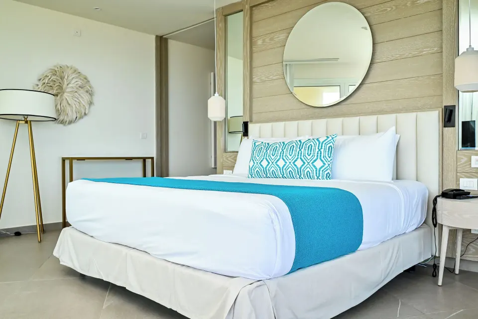 Imperial 1 Bedroom Master Suite bed with turquoise accents at Princess Grand Jamaica Resort.