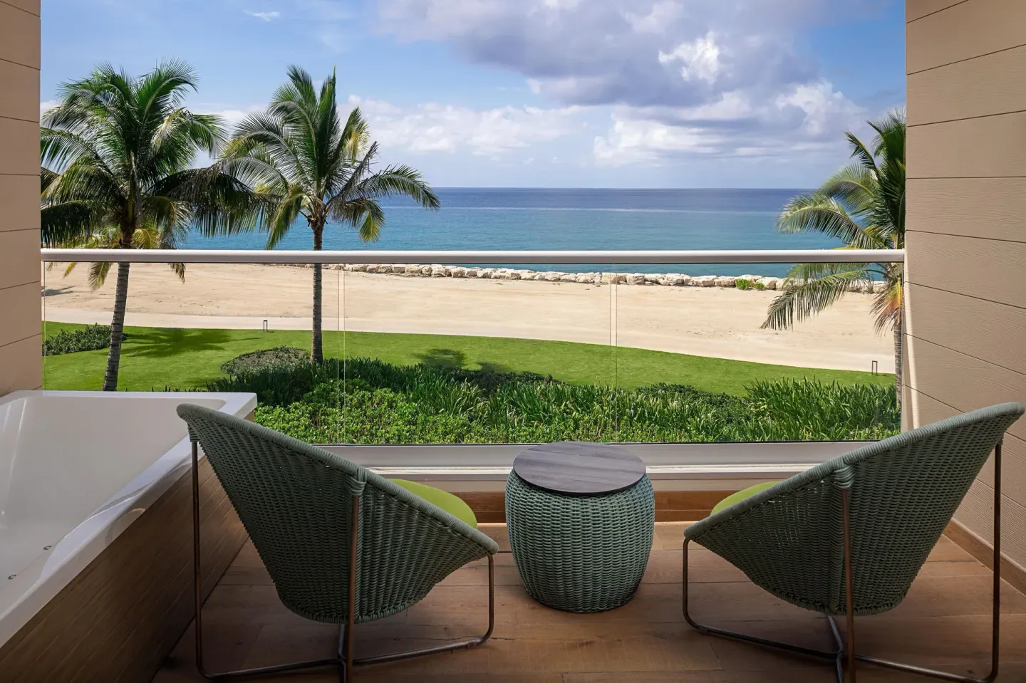 Platinum Junior Suite balcony with chairs, tub and ocean view at Princess Grand Jamaica Resort.
