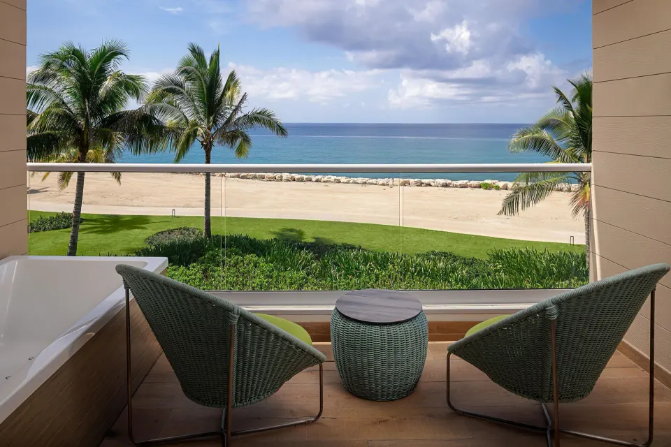 Platinum Junior Suite balcony with chairs, tub and ocean view at Princess Grand Jamaica Resort.