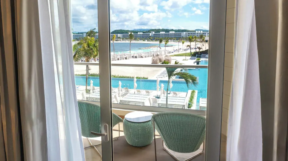 Platinum Junior Suite balcony overlooking pools and beach at Princess Grand Jamaica Resort.