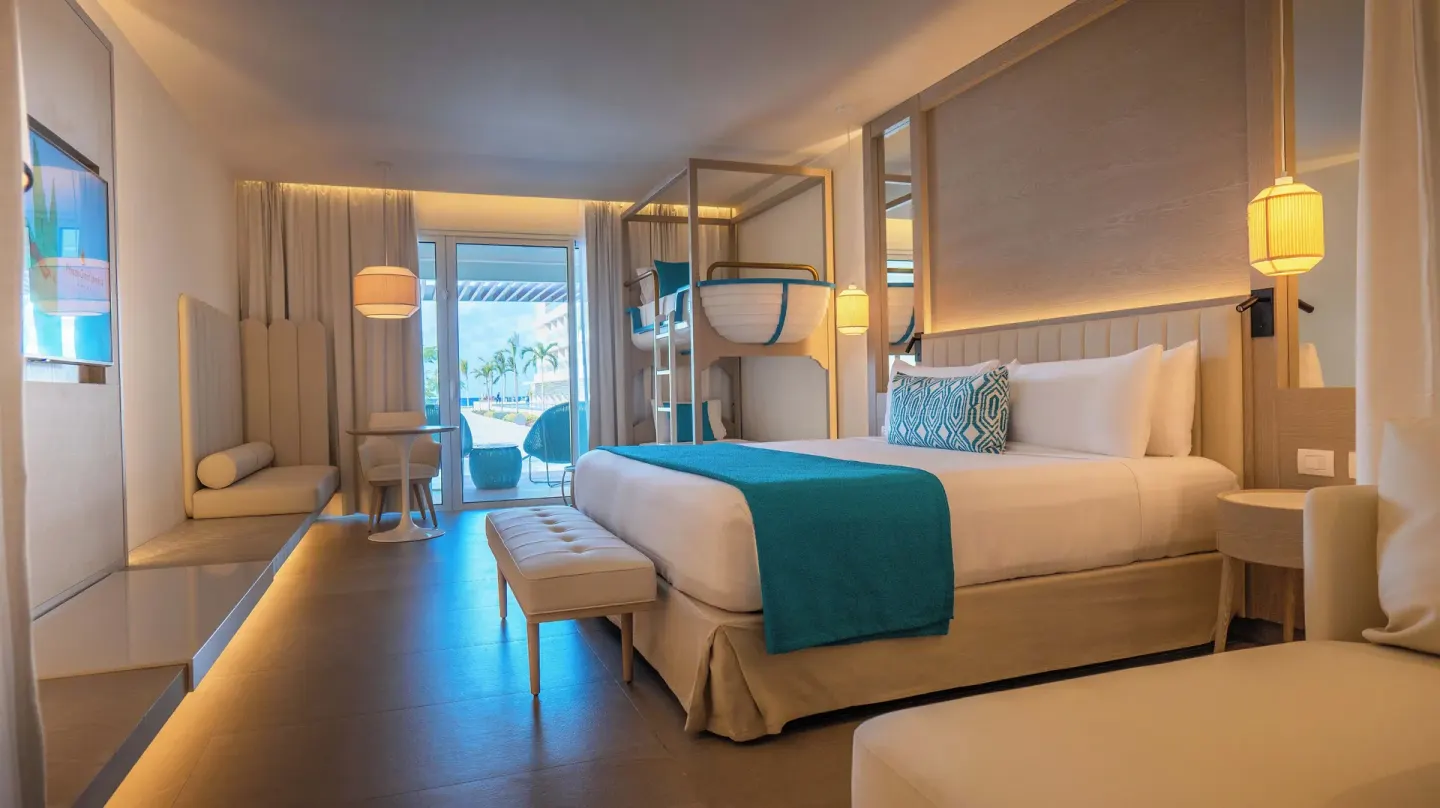 Princess Family Junior Suite with bunk beds, king bed, lounge seating and balcony at Princess Grand Jamaica Resort.