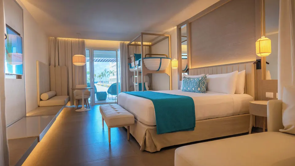 Princess Family Junior Suite with bunk beds, king bed, lounge seating and balcony at Princess Grand Jamaica Resort.