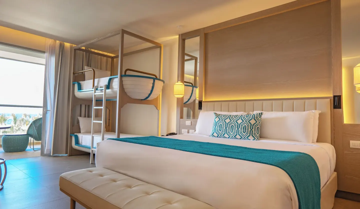 Princess Family Junior Suite with king bed and bunk beds at Princess Grand Jamaica Resort.