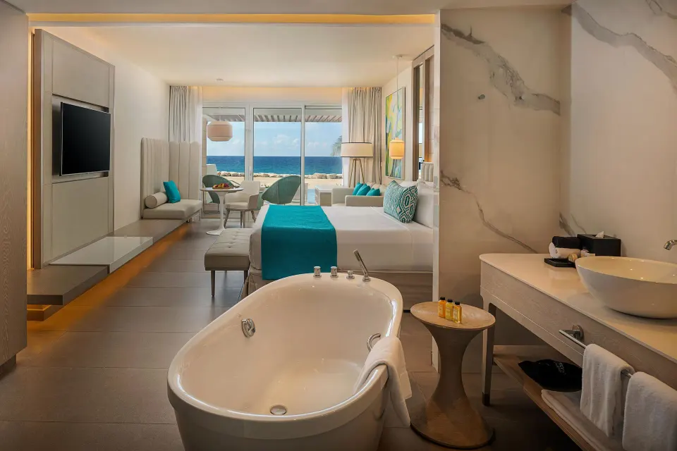 Swim Out Platinum Junior Suite with tub, king bed, and ocean view at Princess Grand Jamaica Resort.