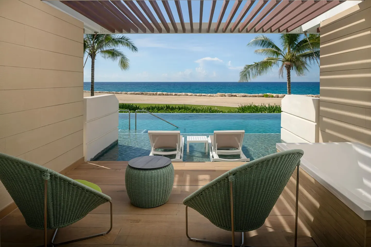 Swim Out Platinum Junior Suite terrace with lounge chairs and ocean view at Princess Grand Jamaica Resort.