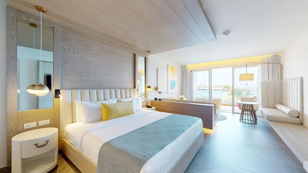 King bed guest room with seating and balcony at Princess Senses The Mangrove Resort.