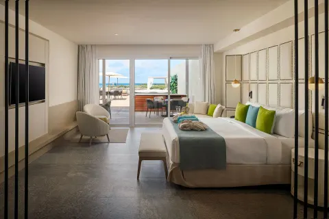 King guest room opening to a patio and ocean beyond at Princess Senses The Mangrove Resort.