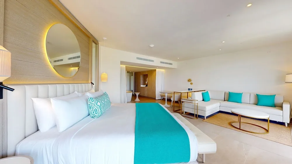 King suite with turquoise accents and lounge seating at Princess Senses The Mangrove Resort.