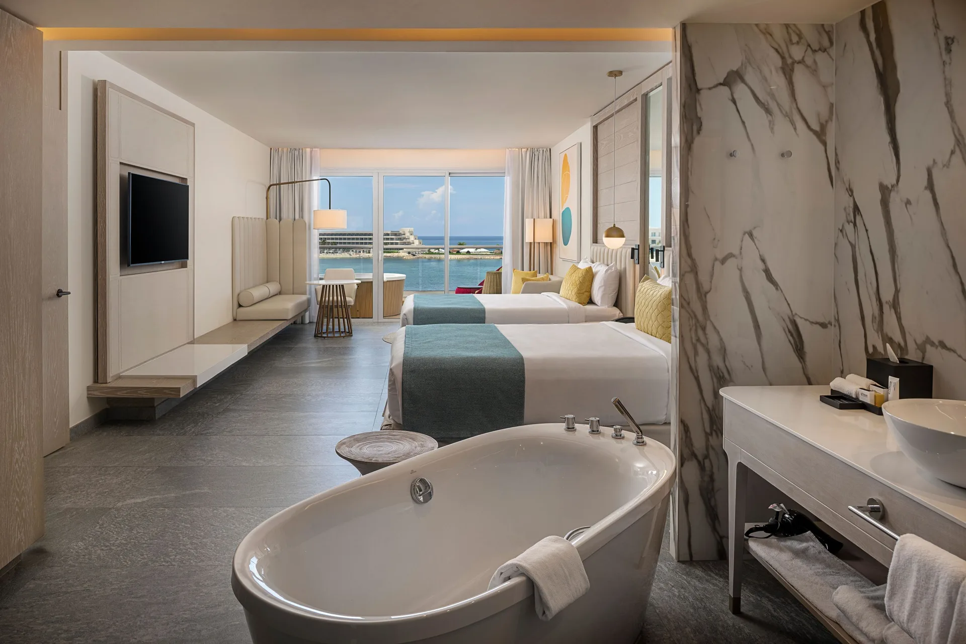 Twin beds, freestanding tub, and sea view in a suite at Princess Senses The Mangrove Resort.