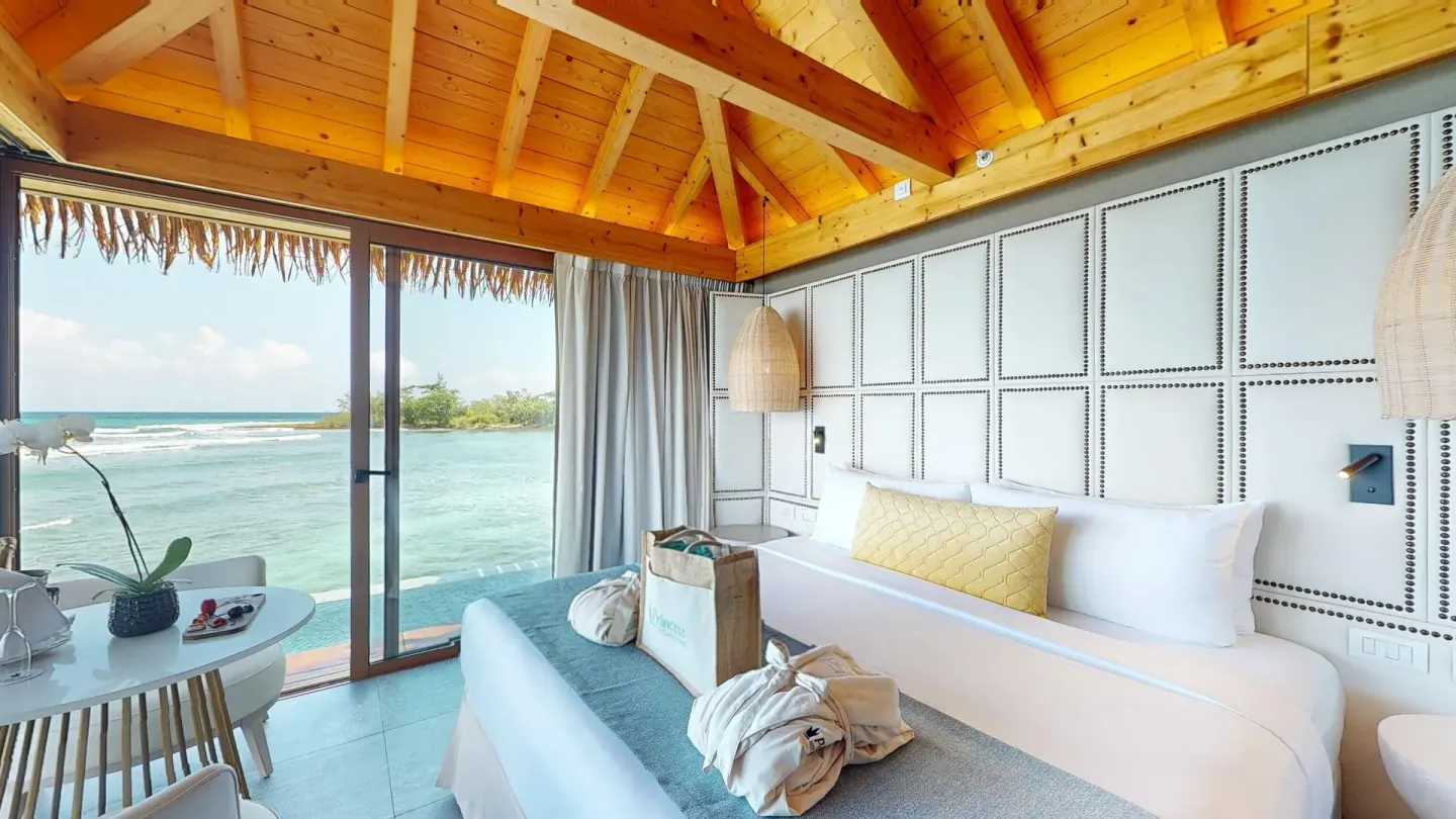 Overwater-style bedroom with king bed and ocean view at Princess Senses The Mangrove Resort.