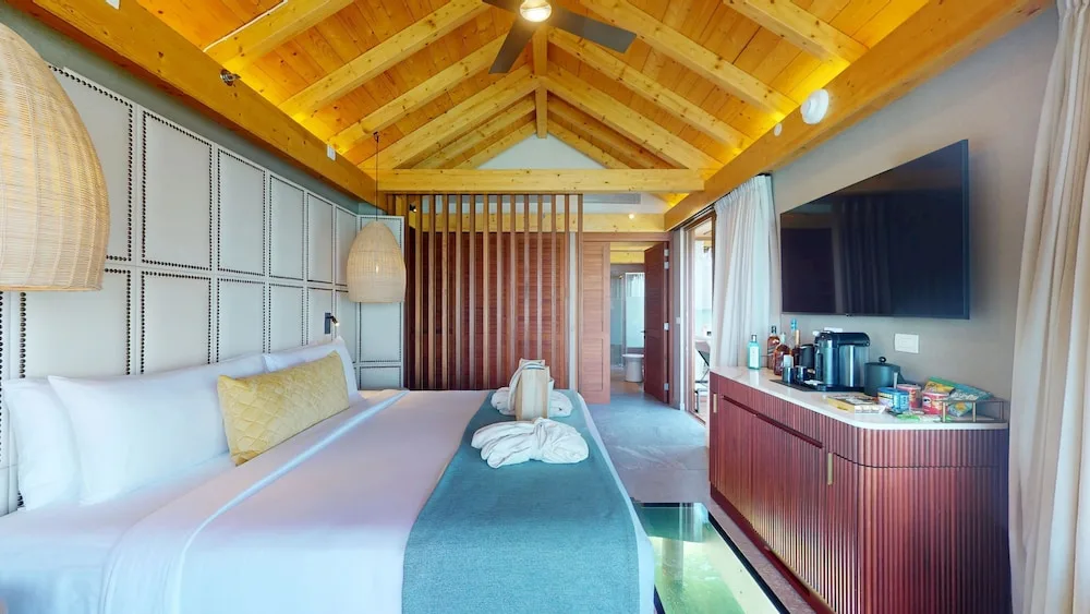 Overwater-style king bed room with wood ceiling at Princess Senses The Mangrove Resort.