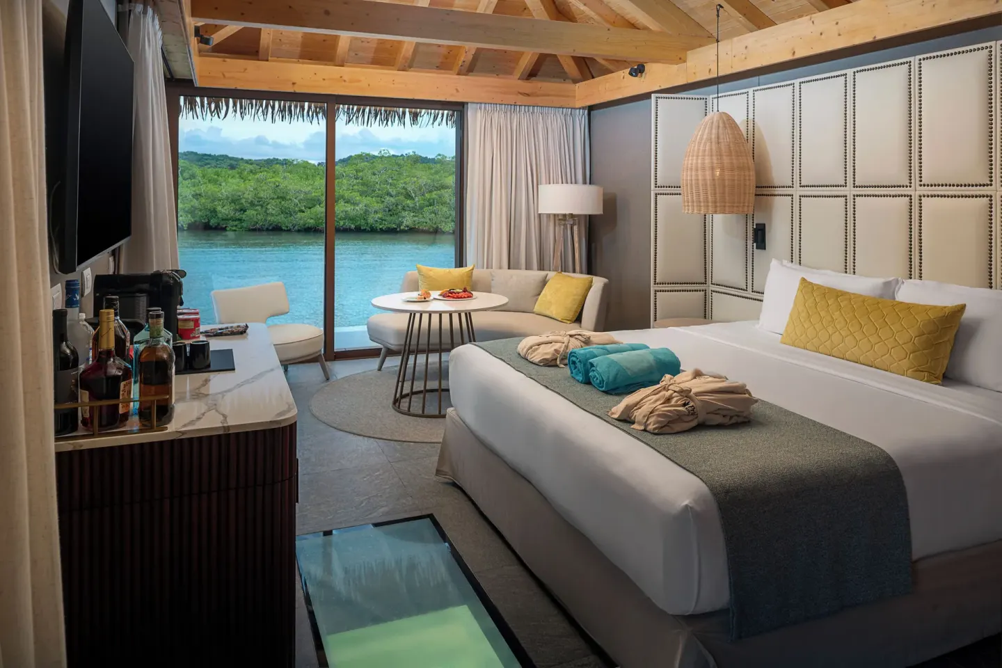King bed and sitting area in an Overwater Villa at Princess Senses The Mangrove Resort.