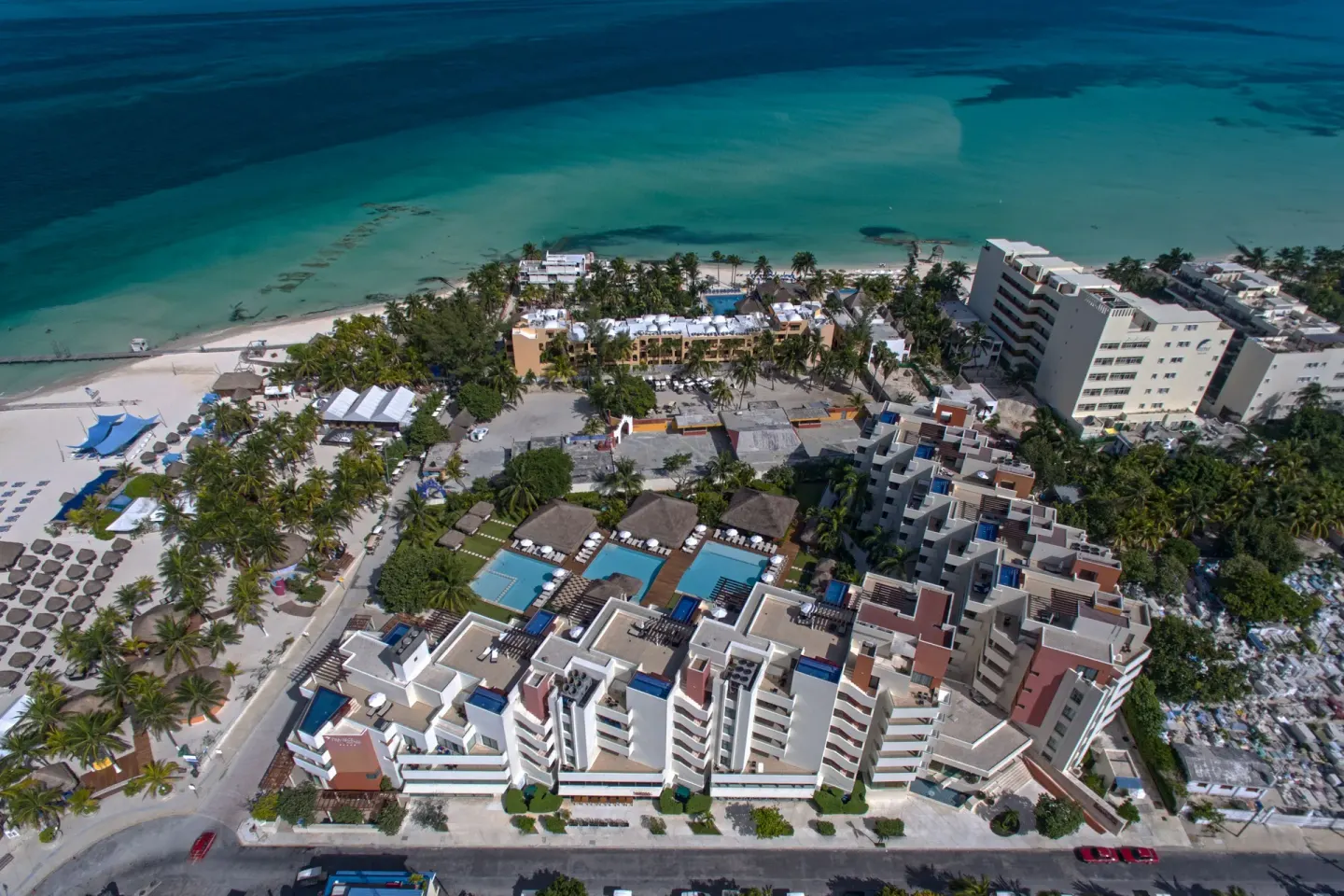 High aerial view of Privilege Aluxes Isla Mujeres with pools, beach, and Caribbean water.
