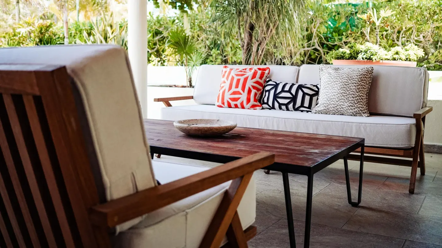 Outdoor cushioned seating and a wood coffee table at Privilege Aluxes Isla Mujeres.