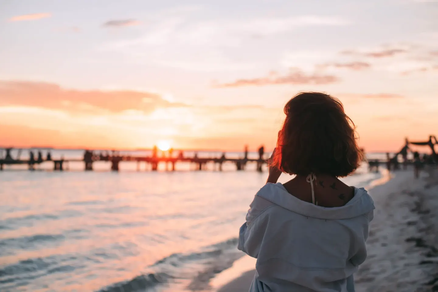 A guest watches the sunset by the shoreline at Privilege Aluxes Isla Mujeres.