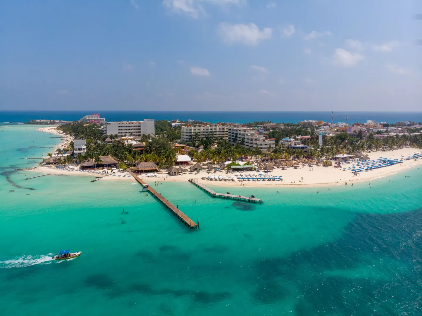 Wide aerial view of Privilege Aluxes Isla Mujeres beachfront and piers.
