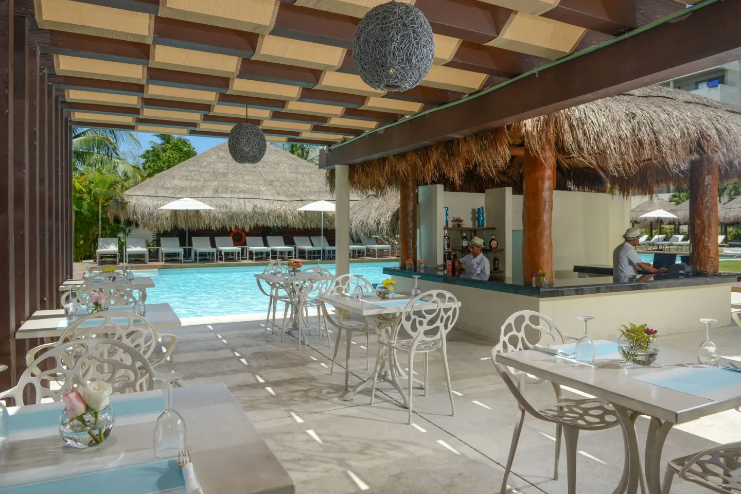 Poolside bar and dining tables at Privilege Aluxes Isla Mujeres.