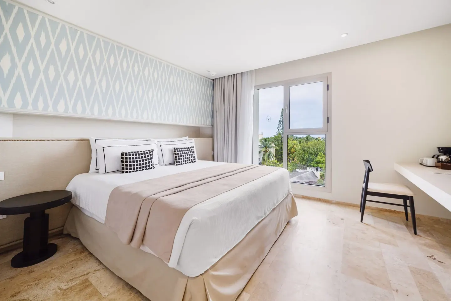 Aluxes Room king bed, window, and desk area at Privilege Aluxes Isla Mujeres.