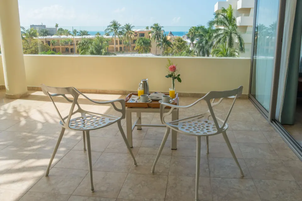 Deluxe Suite Garden View balcony breakfast setting at Privilege Aluxes Isla Mujeres.
